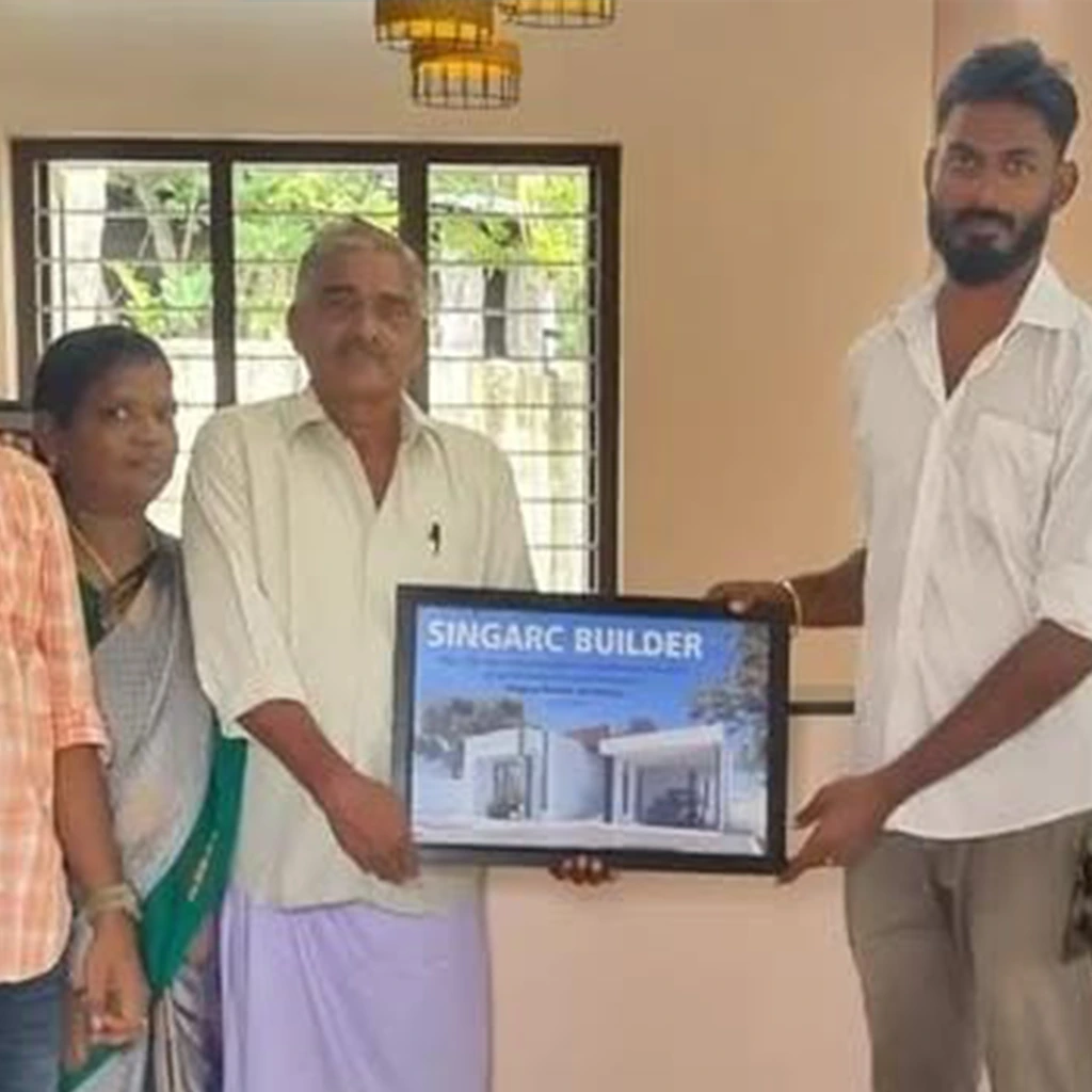 Happy client posing with Singarc Builders team in front of a completed project